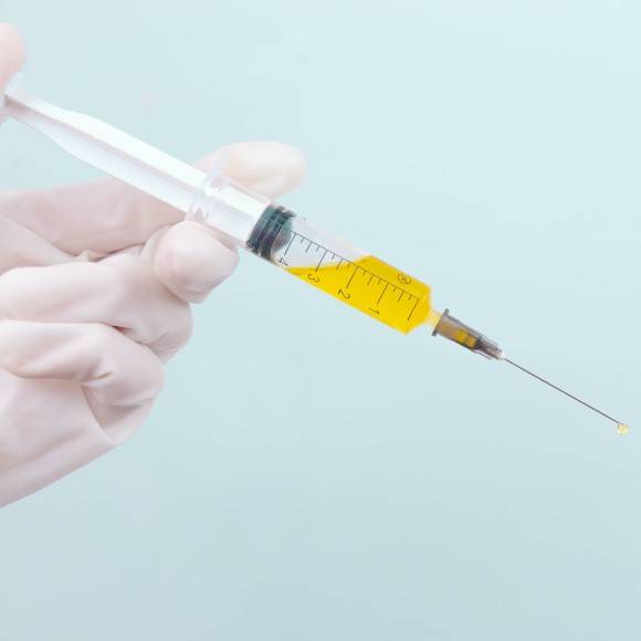 Hand holding syringe