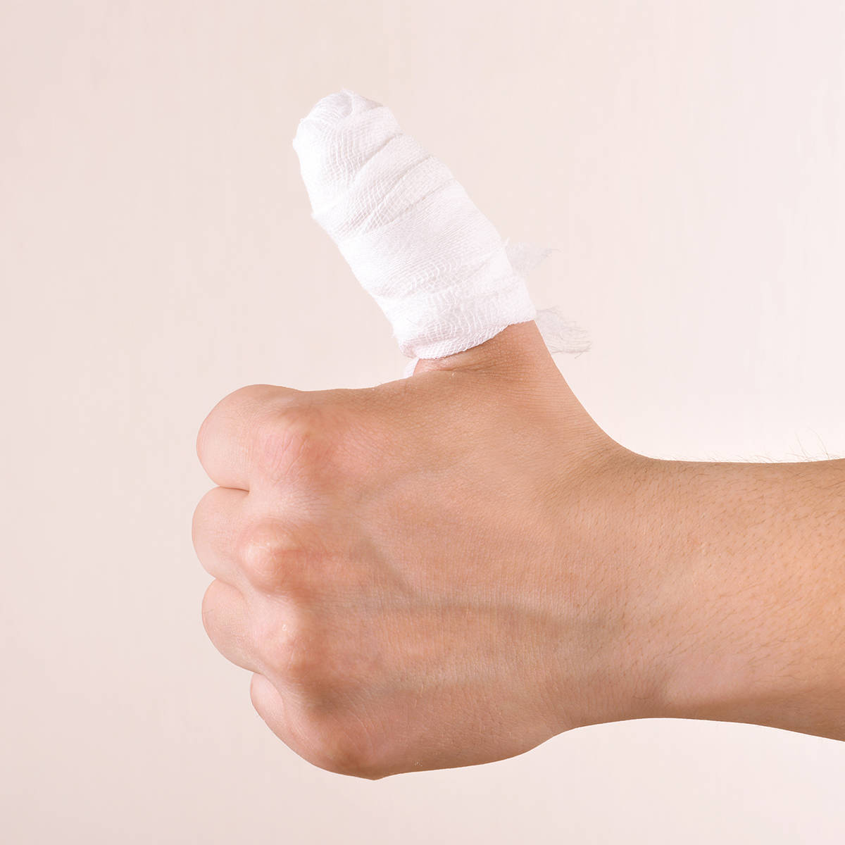 Hand with bandaged thumb making a thumb up sign
