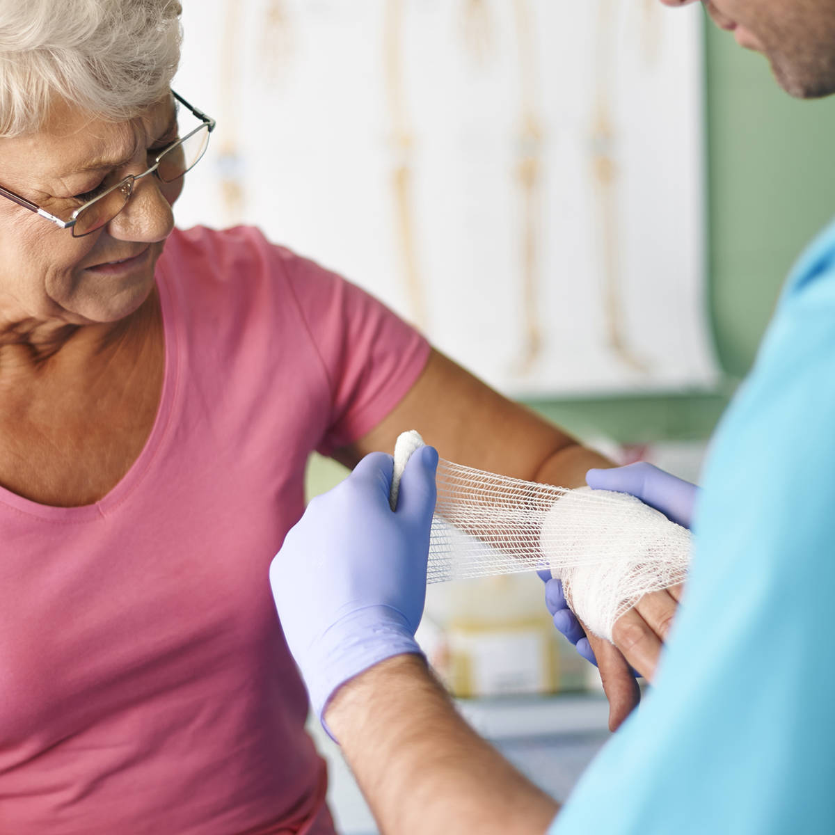 Nurse putting bandage on elderly person